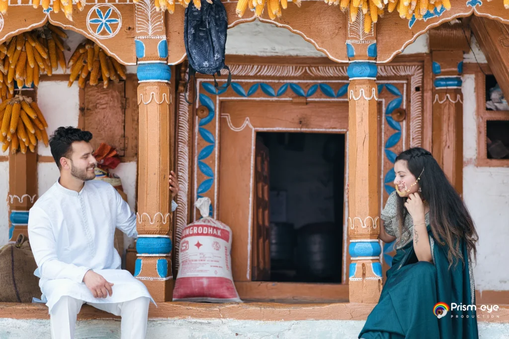 Bride and groom sharing a candid moment outside a traditional village home