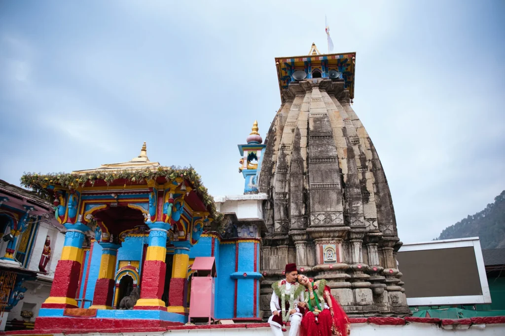 Bride and groom seated outside the sacred Triyuginarayan Temple