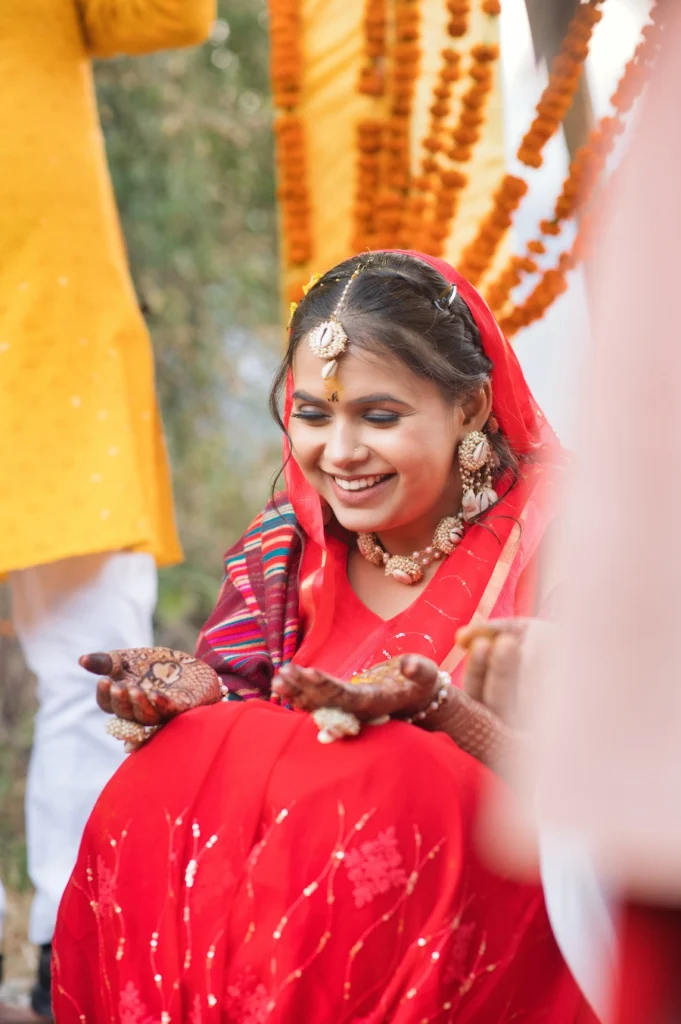 Bride smiling during a traditional wedding ceremony while participating in cultural rituals