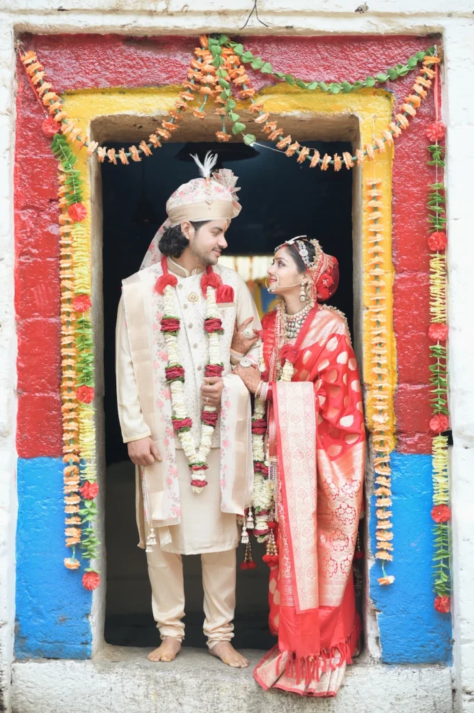 Bride and groom posing at the entrance of a traditional Himalayan temple