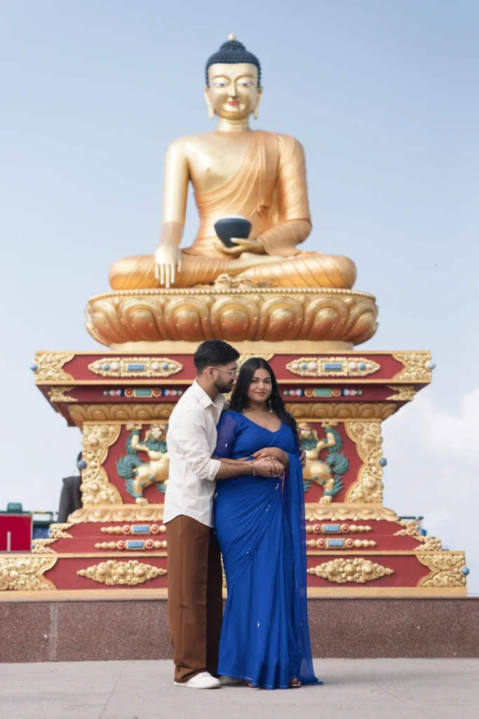 Couple posing in front of the Buddha statue during a pre-wedding shoot at The Dalai Hills in Mussoorie