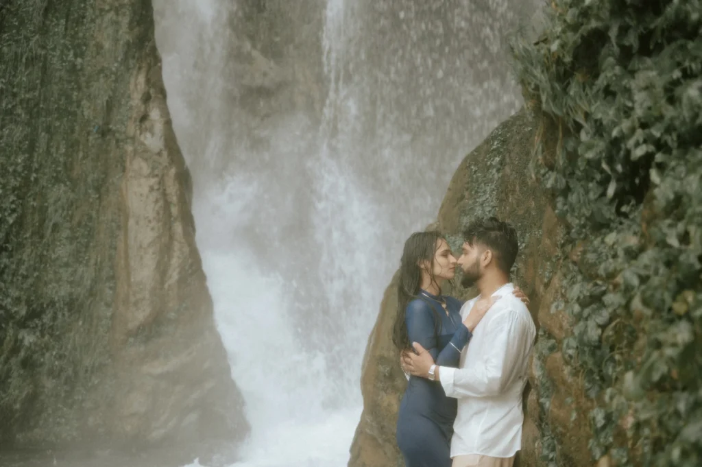 Couple posing beside a waterfall during a romantic pre-wedding shoot near Mussoorie Lake