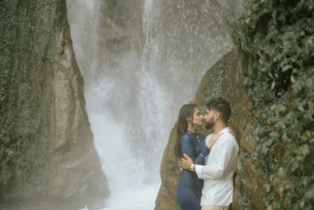 Couple embracing in front of Bhatta Falls during a romantic pre-wedding shoot near Mussoorie