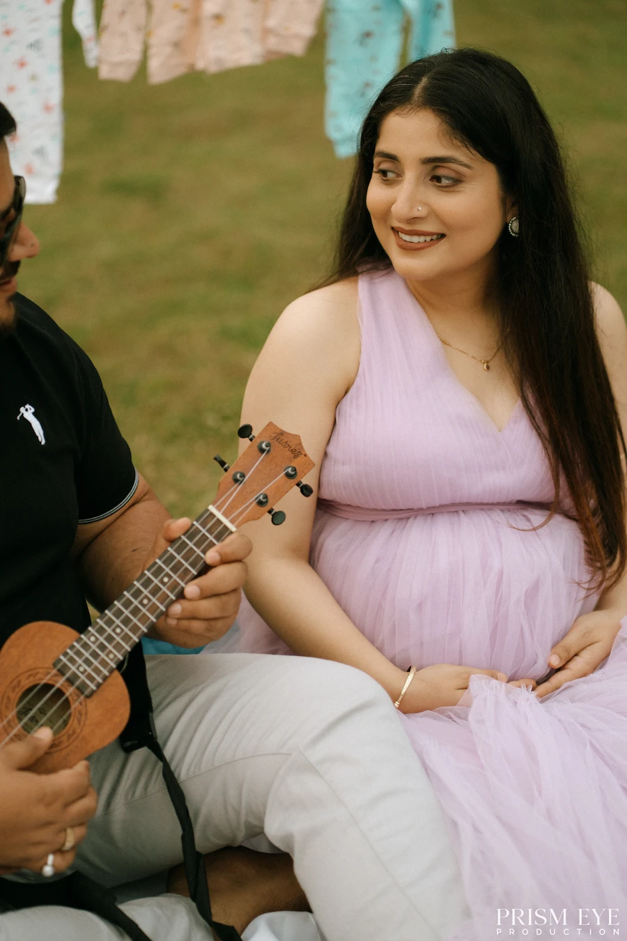 A little music, a lot of happiness, and a beautiful chapter about to begin. Pregnant woman in a lavender dress enjoying a joyful outdoor maternity moment