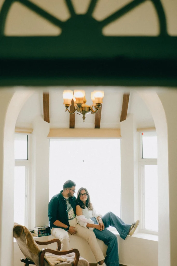 Elegant indoor pre-wedding photography at Gun Hill in Mussoorie with scenic window backdrop