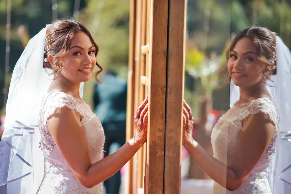 Bride standing beside a glass window with a beautiful reflection portrait in natural light