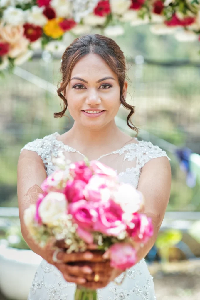 Bride holding a colorful floral bouquet during an outdoor wedding portrait session