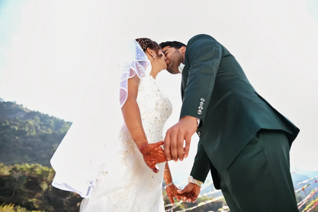 Couple embracing under warm decorative lights during their wedding reception celebration