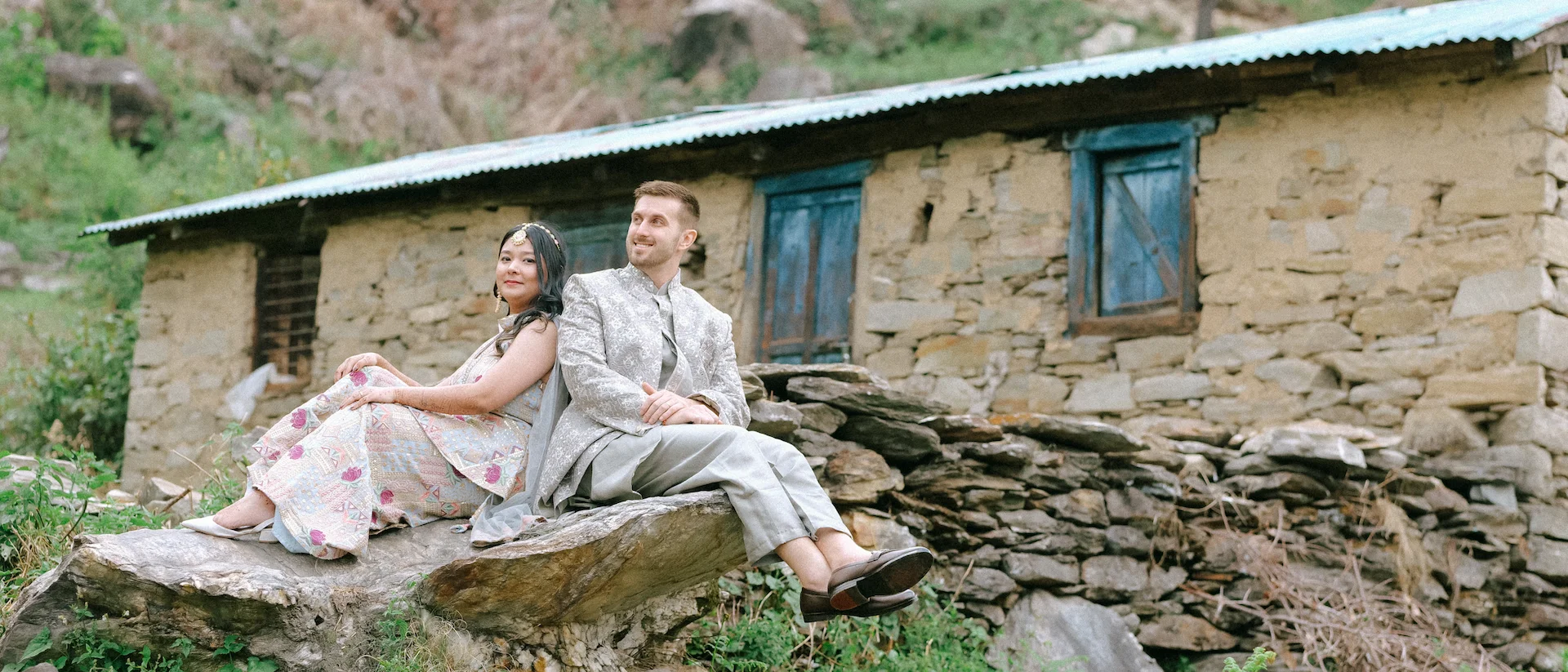Couple posing outside a traditional stone house during a Triyuginarayan pre-wedding shoot