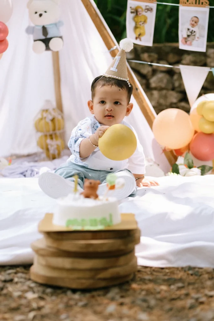 Baby Manraj playing with a balloon beside his birthday cake at Hathipaon Mussoorie