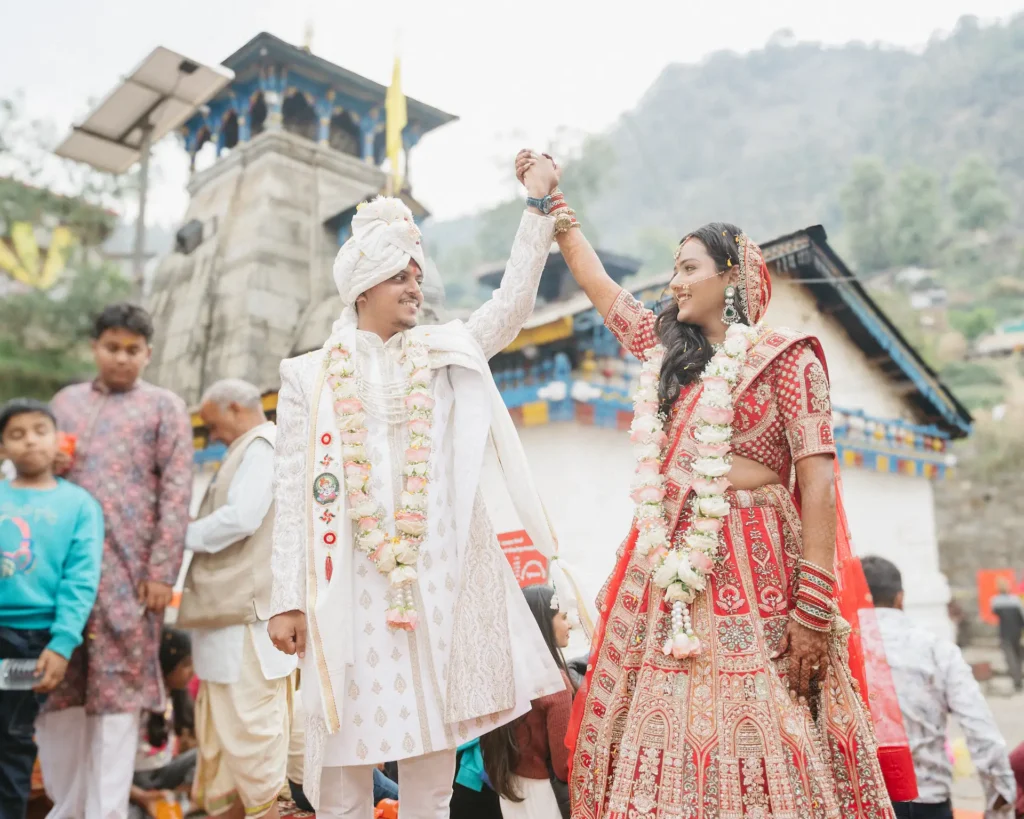 Newly married couple celebrating their wedding with joyful smiles outside the sacred shrine.