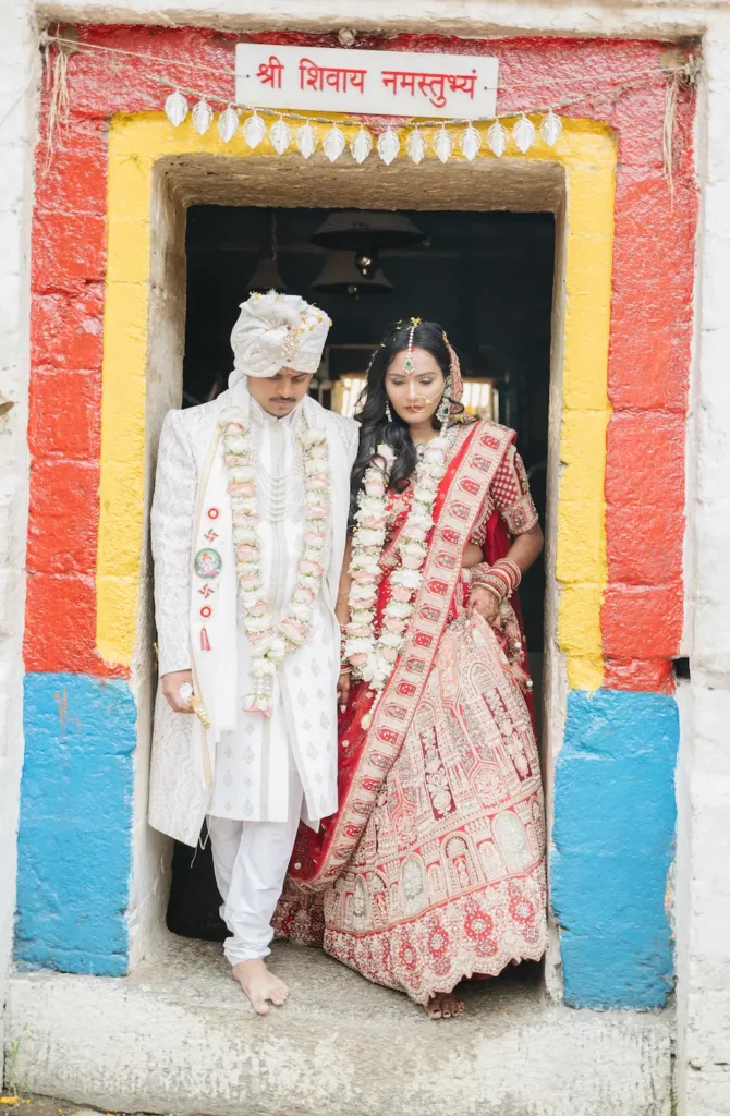 Bride and groom standing at the entrance of a historic Himalayan shrine during their wedding day.