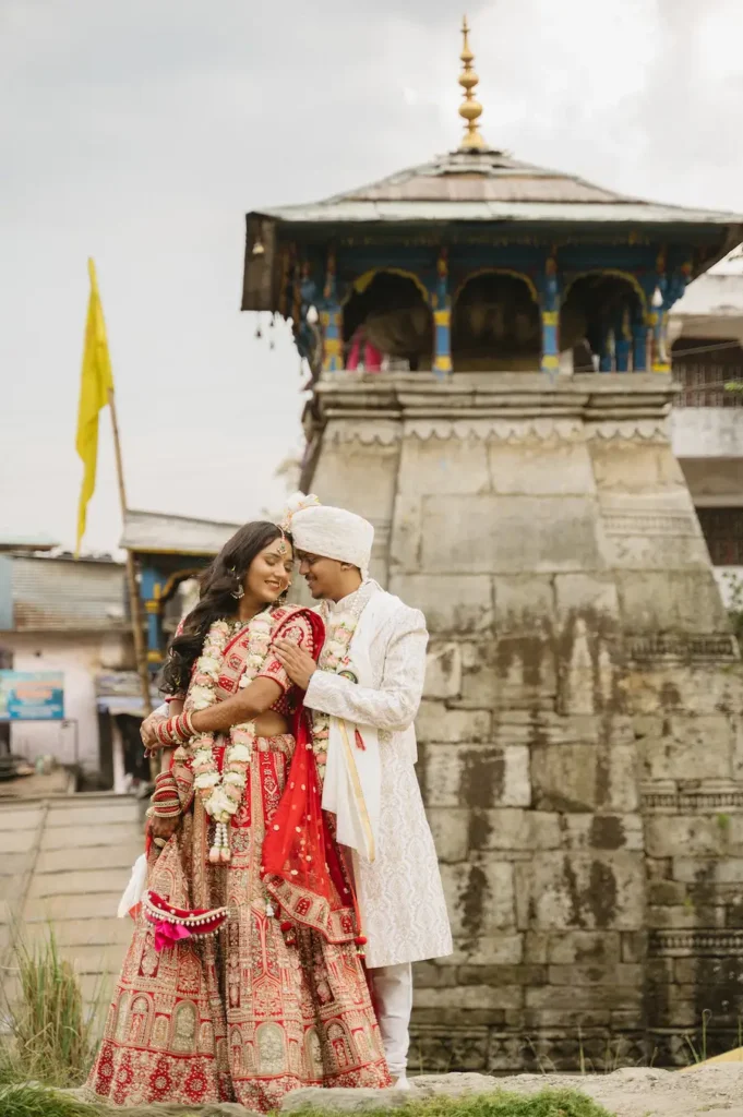 Bride and groom embracing in front of an ancient stone shrine after exchanging their wedding vows.