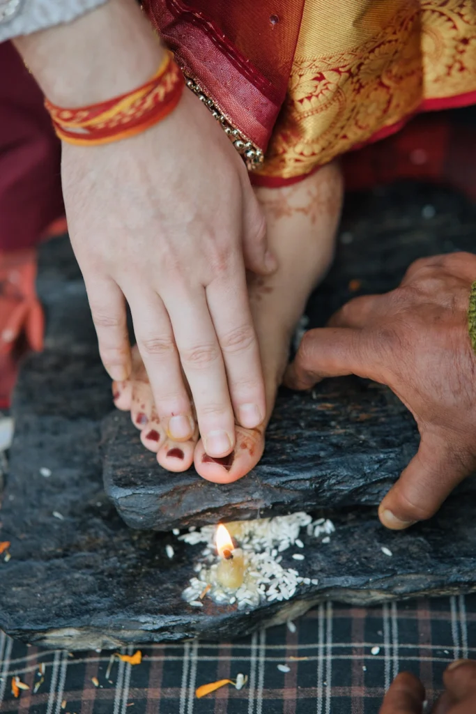 Bride performing a traditional wedding ritual with her feet over a sacred stone