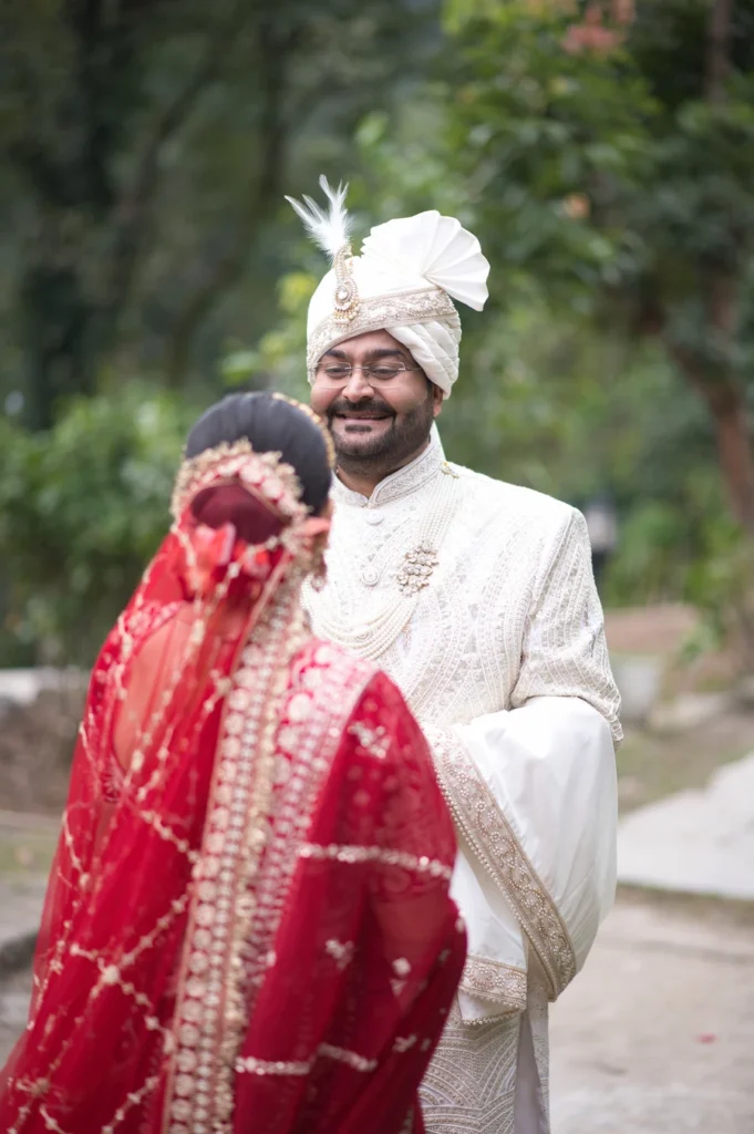 Bride and groom sharing a joyful candid moment during an outdoor wedding ceremony.