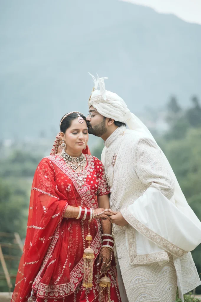 Bride and groom sharing an intimate wedding moment with a mountain backdrop.