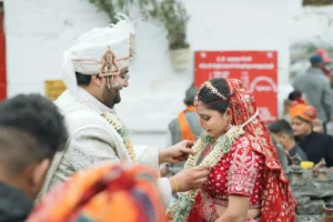 Bride and groom performing a traditional Hindu wedding ritual surrounded by family and guests.
