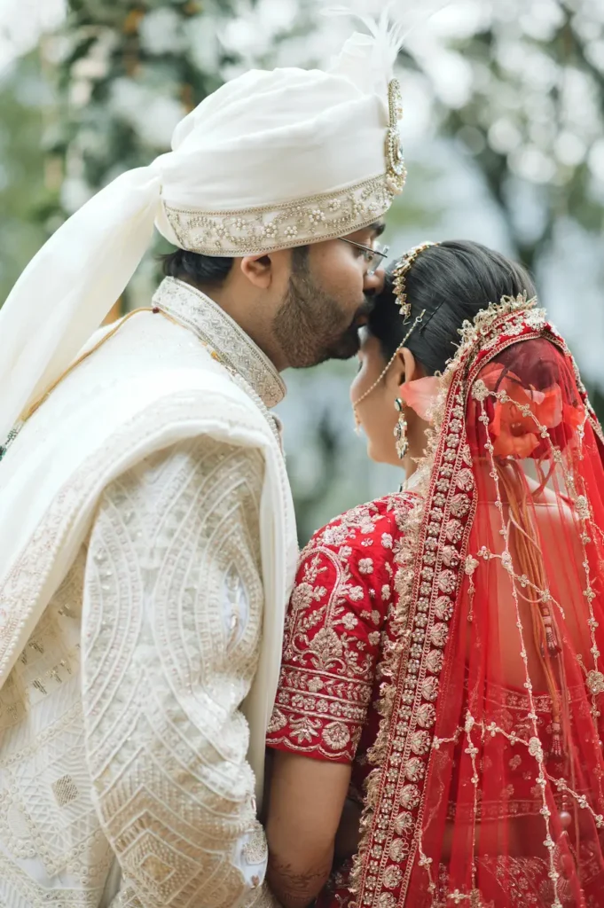 Bride and groom sharing an intimate wedding moment in traditional attire.