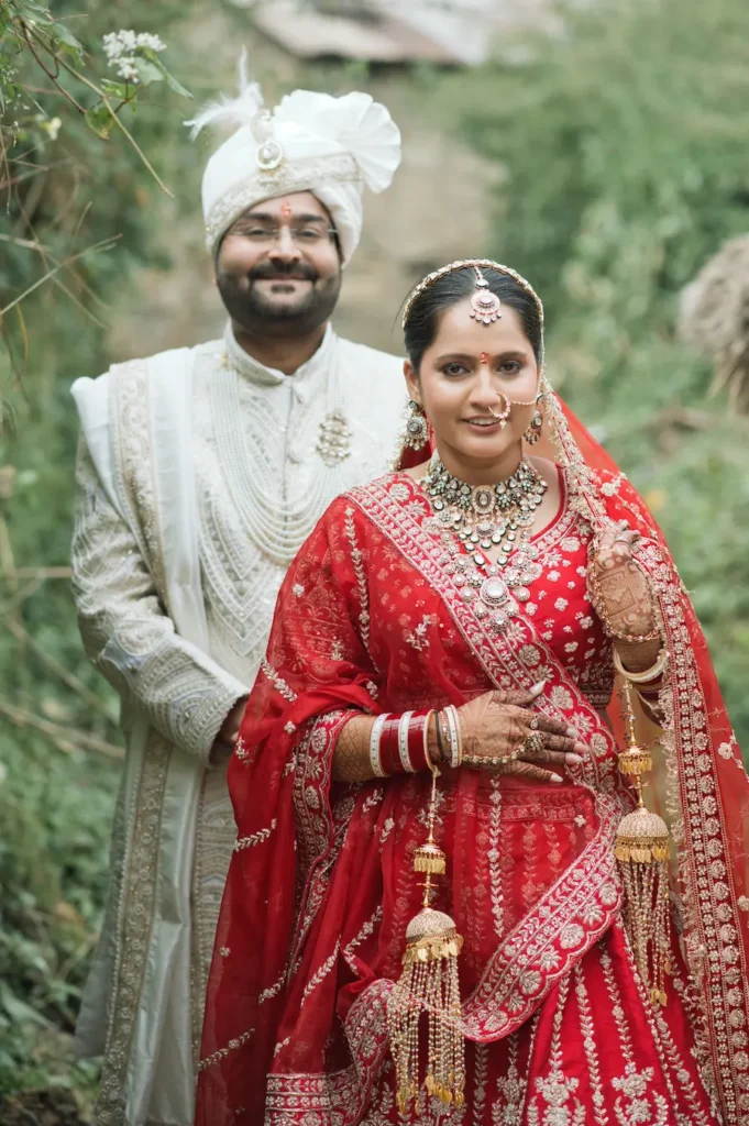 Candid bride and groom portrait during a wedding in Triyuginarayan, with the bride in a red lehenga and groom in traditional ivory attire.