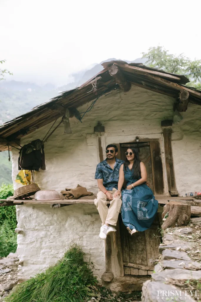 Couple sitting outside a traditional mountain home in Chilnari Neck, Chakrata
