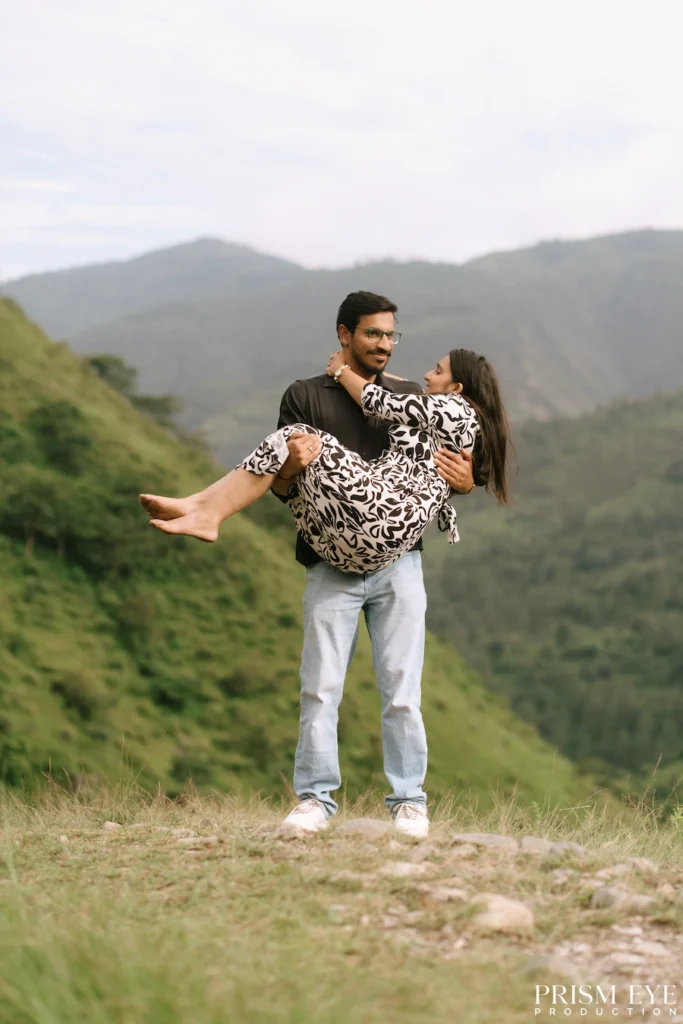 Couple enjoying a playful moment in a mountain meadow in Chakrata
