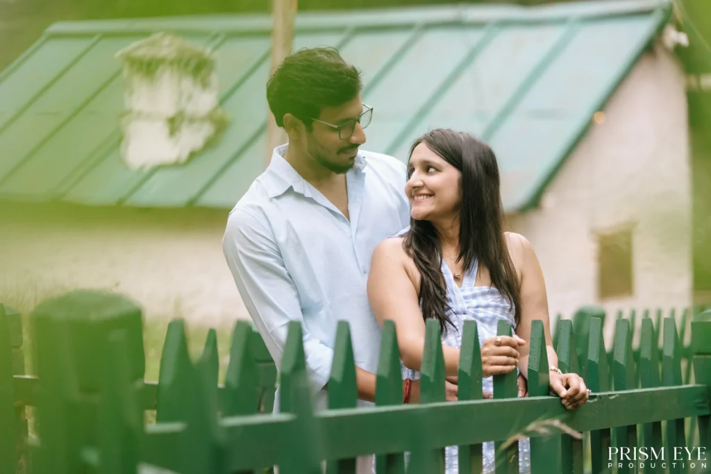 Couple sharing a romantic moment by a wooden fence in Chakrata
