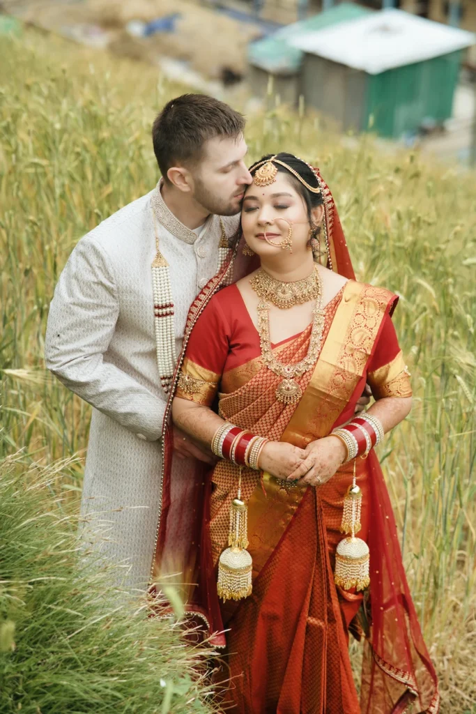 Bride and groom sharing a tender moment together in a field of tall grass