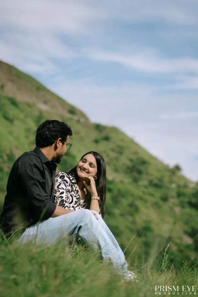 Couple sitting together on a grassy hillside in Deoband, Chakrata