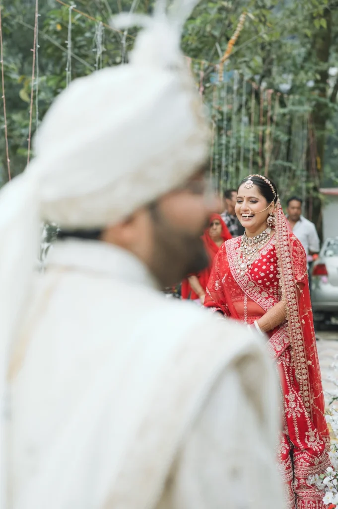 Candid bride and groom wedding portrait in Triyuginarayan, with the smiling bride in a red lehenga.