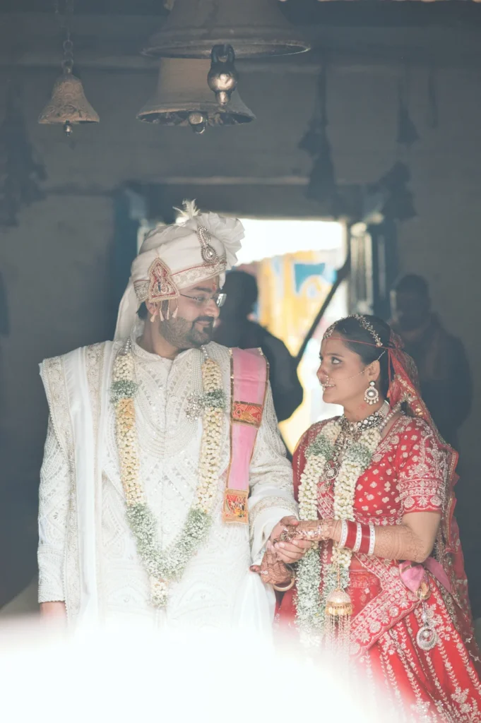 Bride and groom sharing a candid wedding moment inside a traditional temple in Triyuginarayan.