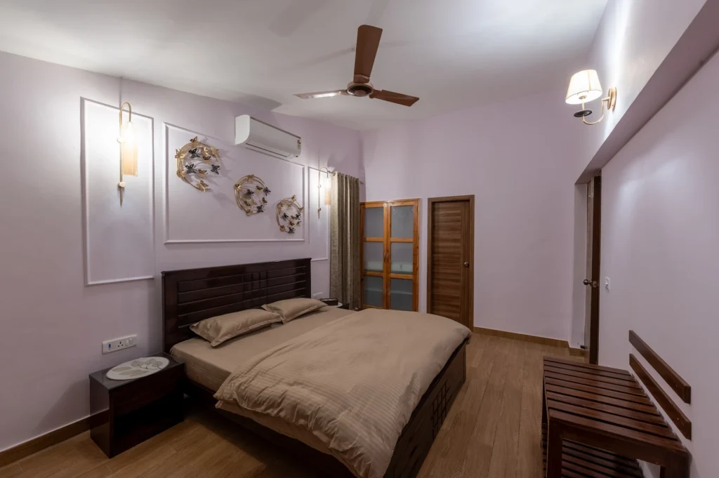 Luxury villa bedroom with modern wooden furniture in Jharipani, Mussoorie, Uttarakhand.