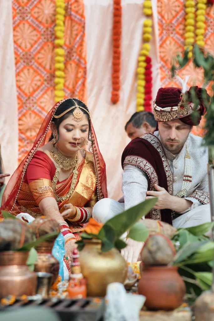 A traditional Indian wedding couple participating in a sacred Havan ceremony at Triyuginarayan Temple.