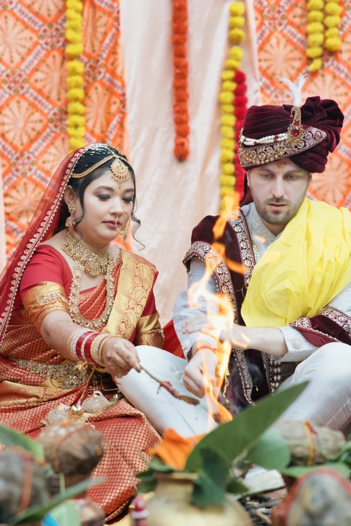 Indian bride and groom performing a sacred fire Havan ritual together at Triyuginarayan Temple.