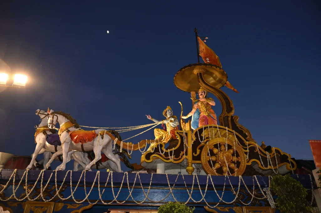 Beautifully illuminated traditional chariot display captured at an evening event. Traditional Indian stage decoration with Krishna and Arjuna chariot display