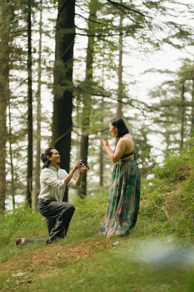 A man down on one knee as he surprises his partner with a proposal