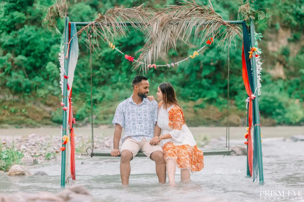 Couple sharing a romantic moment on a decorated swing during a proposal photoshoot in Rishikesh.
