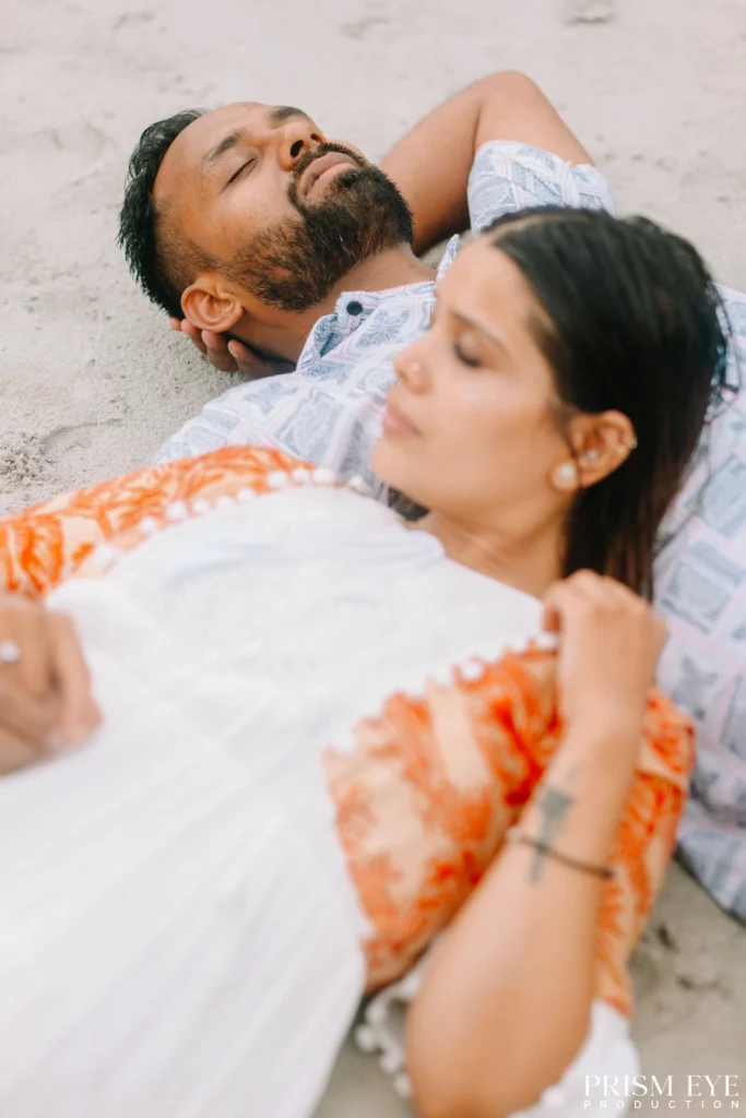 Couple lying together on the sandy banks of the Ganga during a romantic photoshoot in Rishikesh.