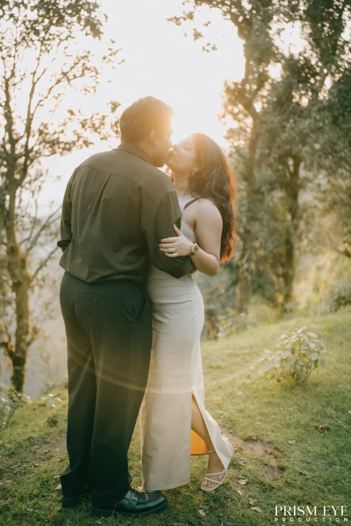 A couple sharing a romantic kiss while standing in the warm evening light