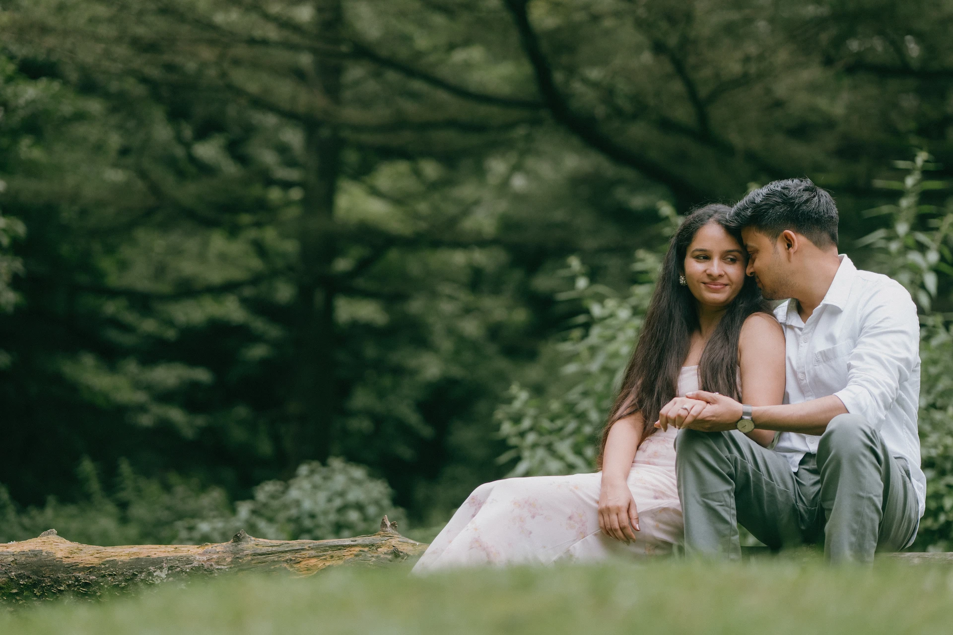 Couple sitting close together in a lush pine forest during a pre-wedding photoshoot in Mussoorie