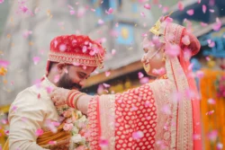 A magical wedding moment as flower petals rain over the bride and groom, celebrating love, happiness, and the beginning of their new journey together. Bride and groom celebrating beneath a shower of flower petals during their traditional Hindu wedding ceremony.