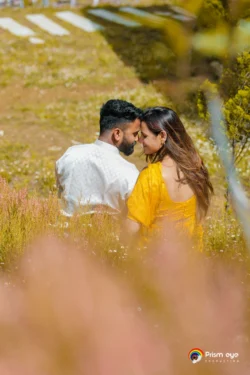 A heartfelt candid moment as the couple shares a quiet embrace during their outdoor pre-wedding photoshoot surrounded by nature. Couple sharing a candid romantic moment in a garden during their pre-wedding photoshoot in natural daylight.