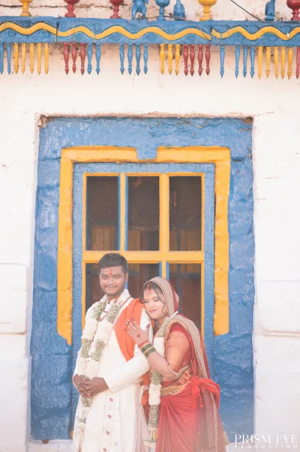 Bride and groom posing together in a colorful temple courtyard
