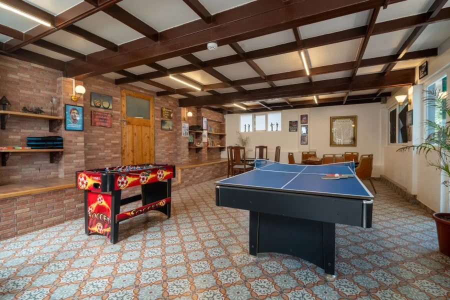 Spacious indoor games lounge in Dehradun featuring table tennis, entertainment facilities, and a comfortable recreation space. Indoor games lounge with table tennis and recreation area in a luxury villa in Dehradun, Uttarakhand.
