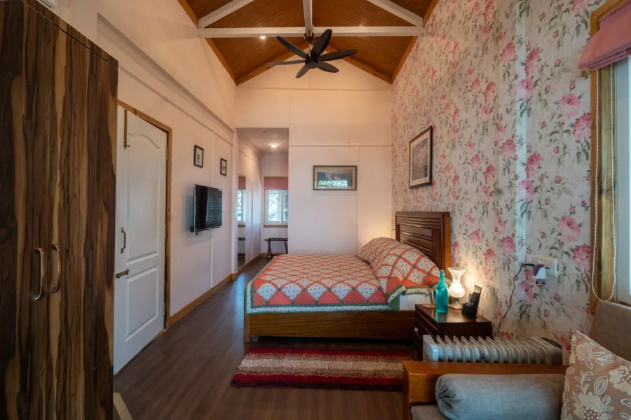 Stylish luxury bedroom in Landour, Mussoorie featuring warm wooden interiors, elegant décor, and a peaceful mountain retreat ambiance. Elegant luxury bedroom with wooden ceiling in Landour, Mussoorie, Uttarakhand.