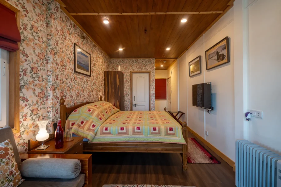 Comfortable premium bedroom suite in Landour, Mussoorie featuring elegant interiors, warm wooden finishes, and a relaxing mountain retreat ambiance. Premium luxury bedroom suite with wooden ceiling in Landour, Mussoorie, Uttarakhand.